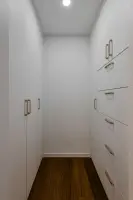 골드 손잡이로 포인트를 준 화이트 워크인 드레스룸